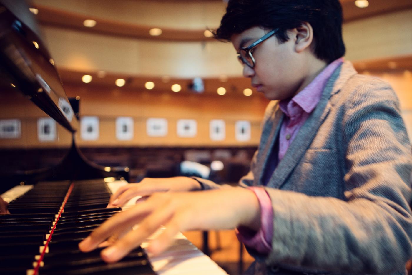 A young boy playing a piano.