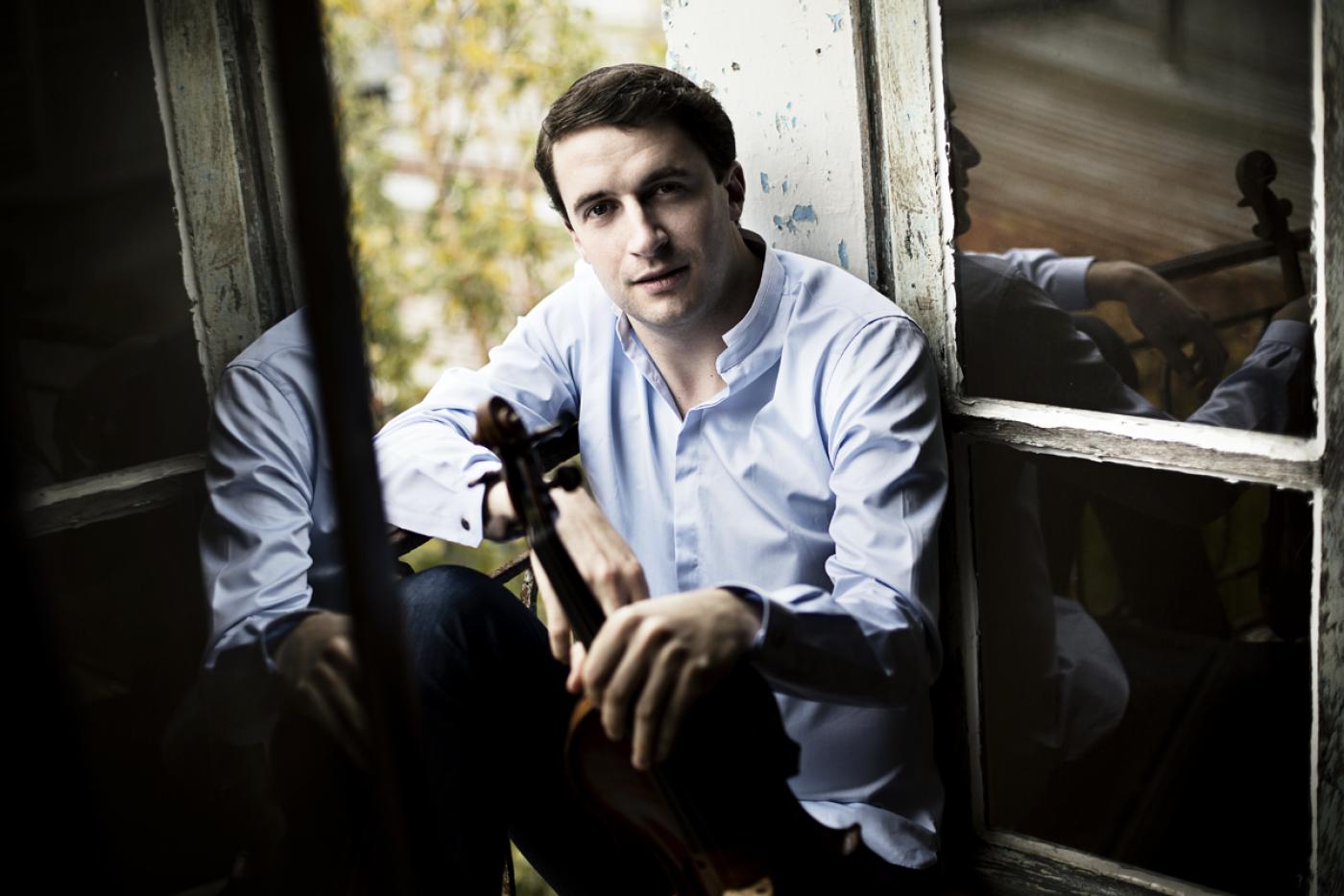 Noah Bendix-Balgley holding a violin.