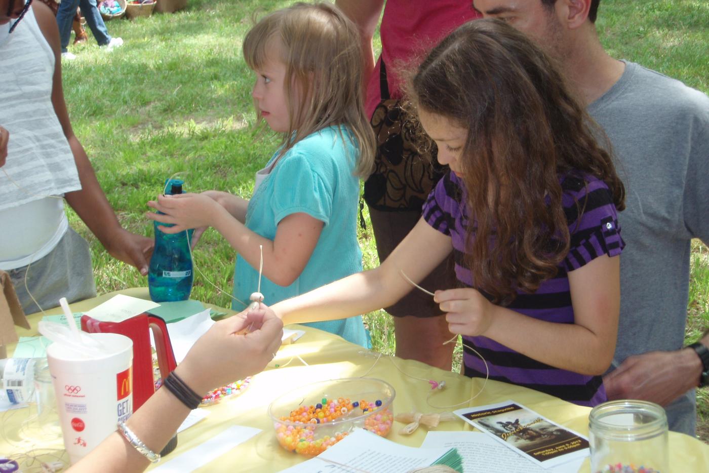 A family participating in arts and crafts outside.