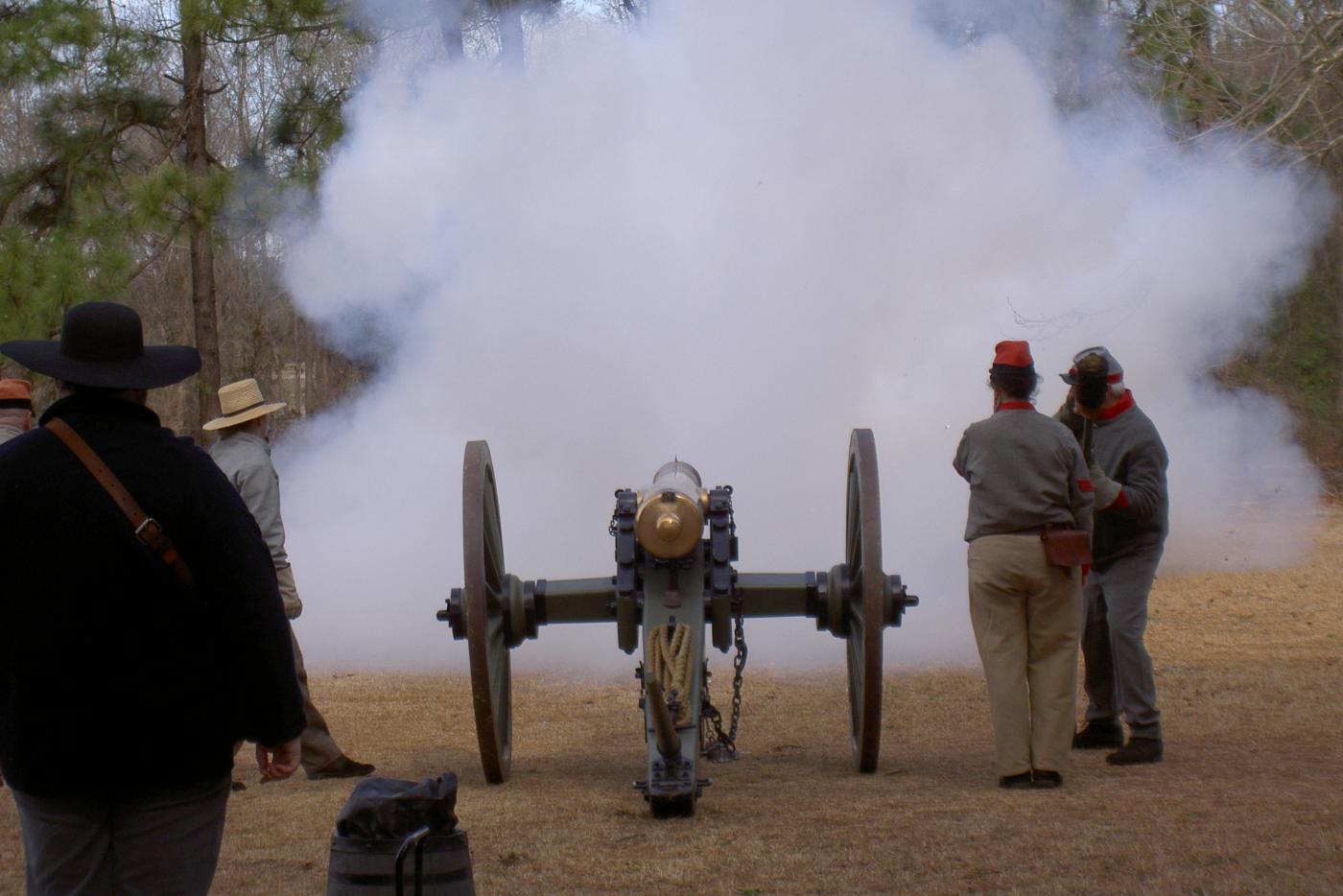 Historical interpreters dressed as Civil War soldiers, firing a cannon.