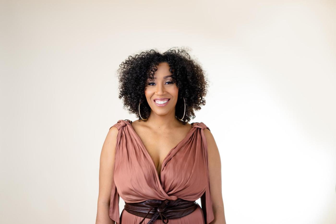 A headshot of a woman, Rissi Palmer, smiling.