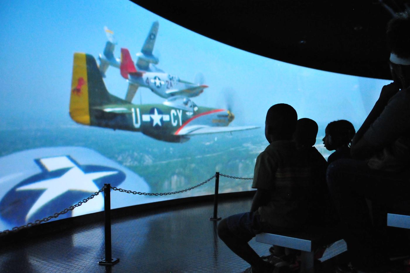 Children looking at a screen showing planes. 