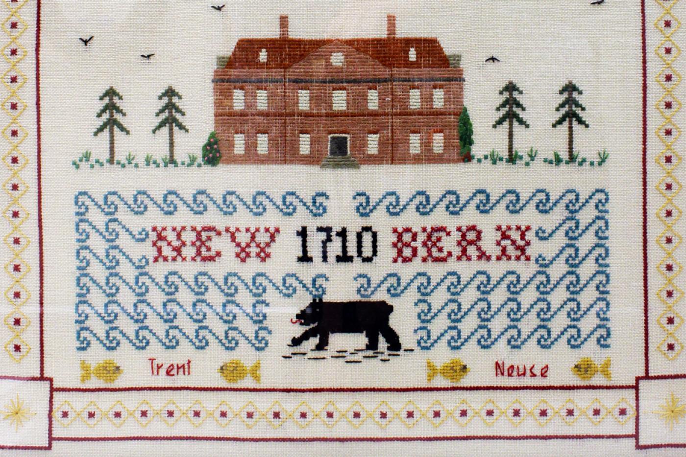 Needle art of Tryon Palace. The text "New Bern 1710" is on the front, as well as an image of a black bear.