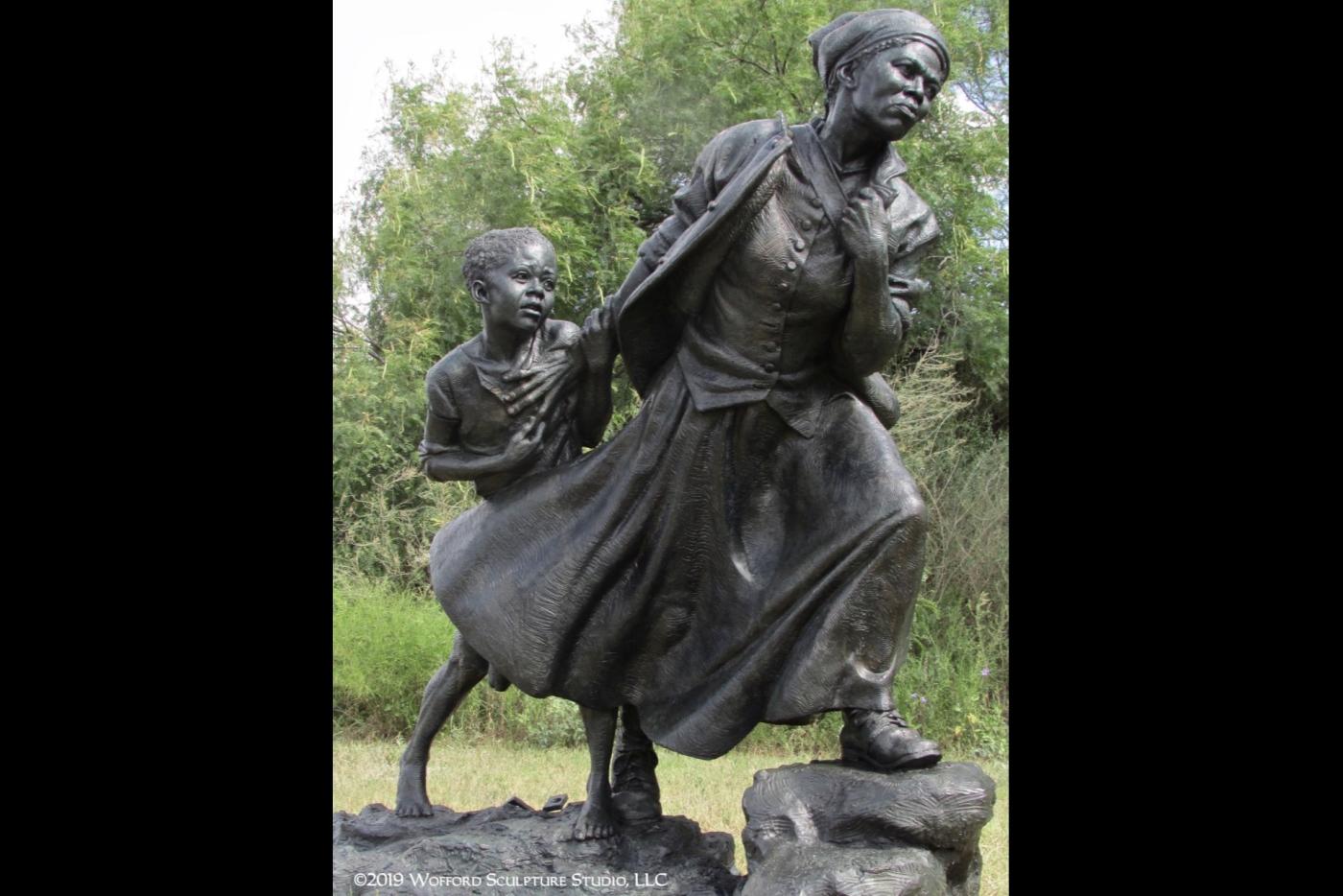 A statue depicting Harriet Tubman guiding a child.