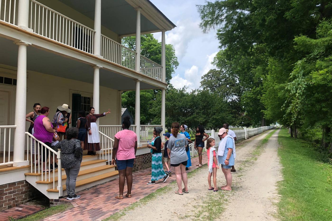 A group of tourists led by a historical interpreter on the grounds of Somerset Place.