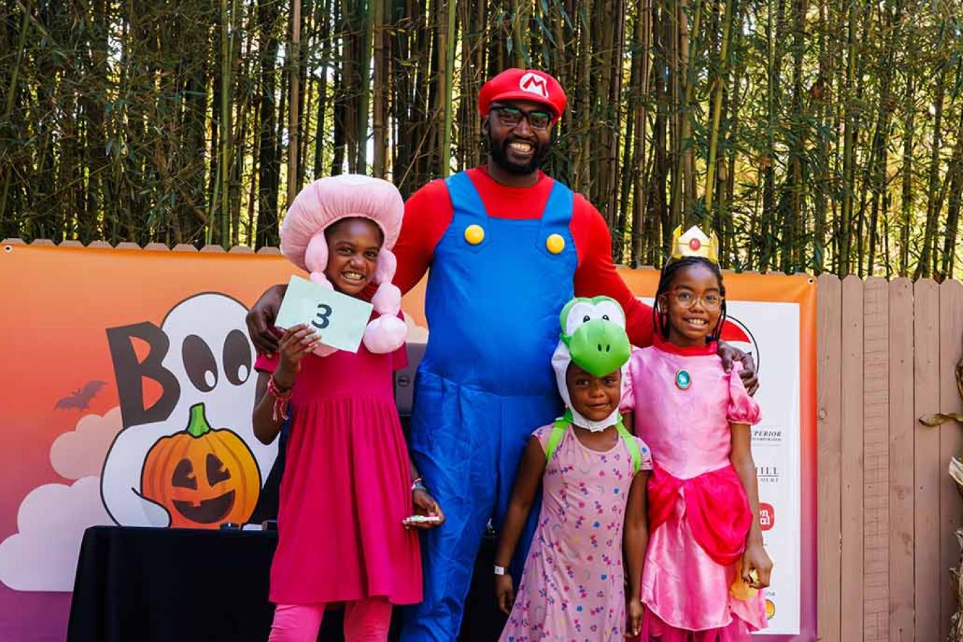 Family dressed in costumes like characters from Mario