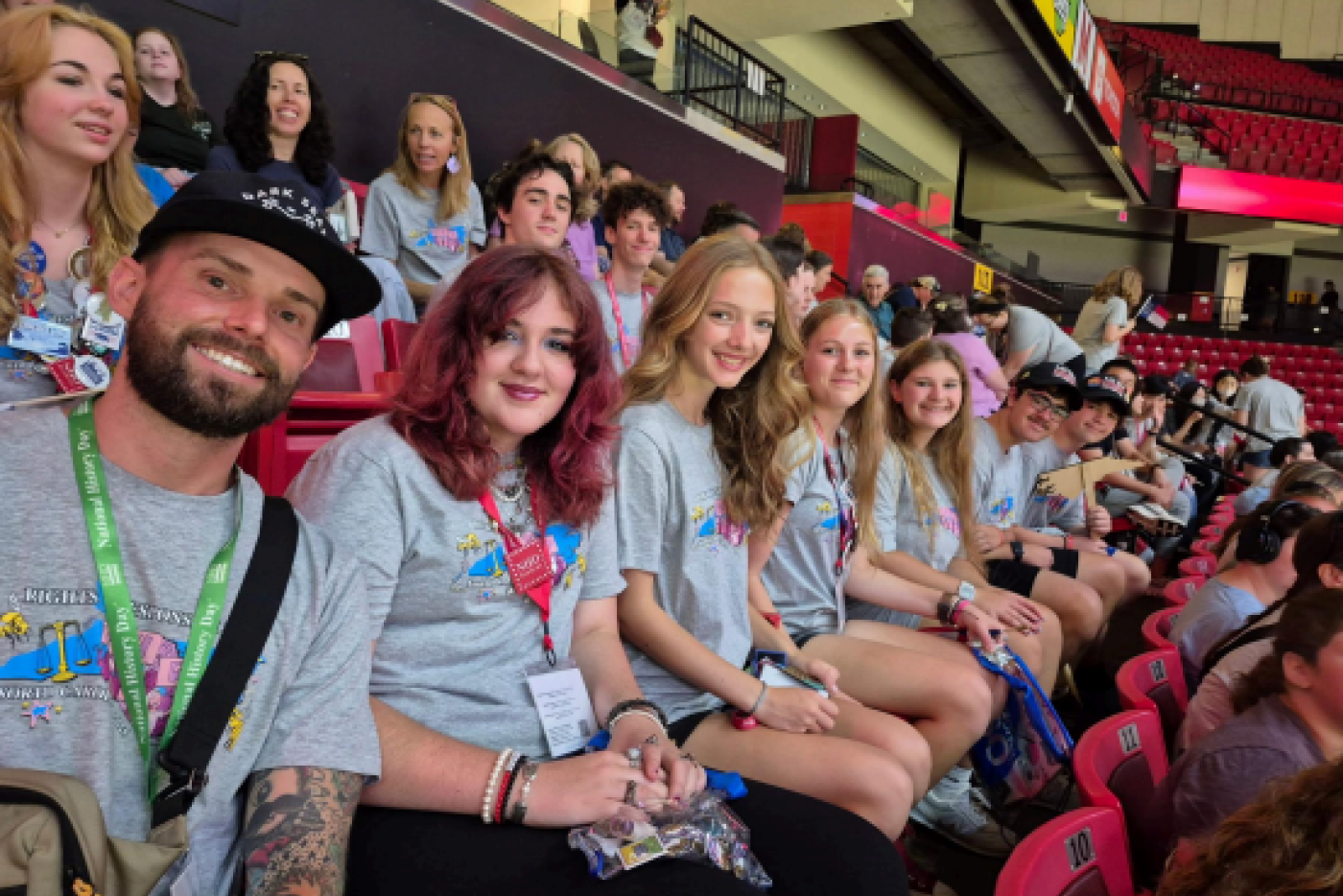 a group of people sitting in an auditorium and facing the camera while smiling