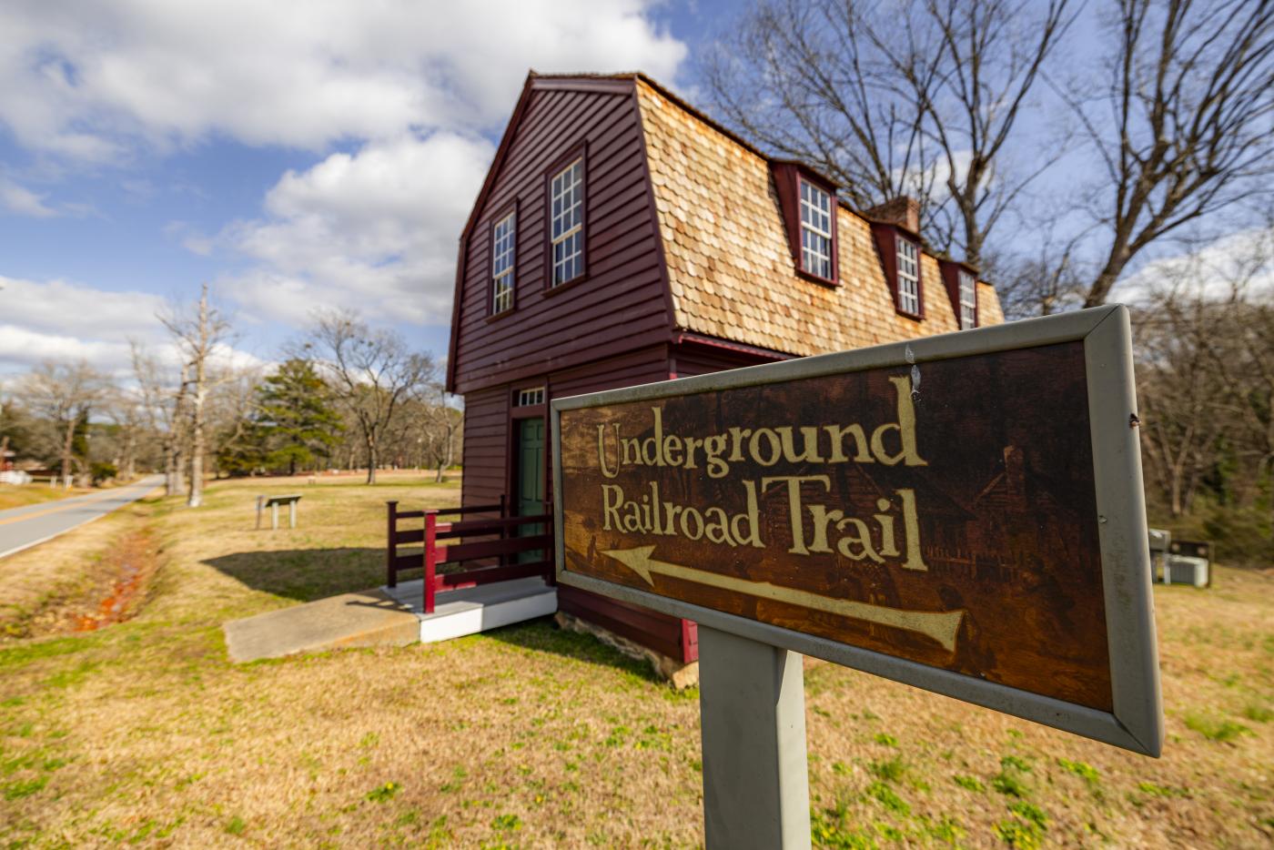 A sign reading "Underground Railroad Trail" in front of a building.