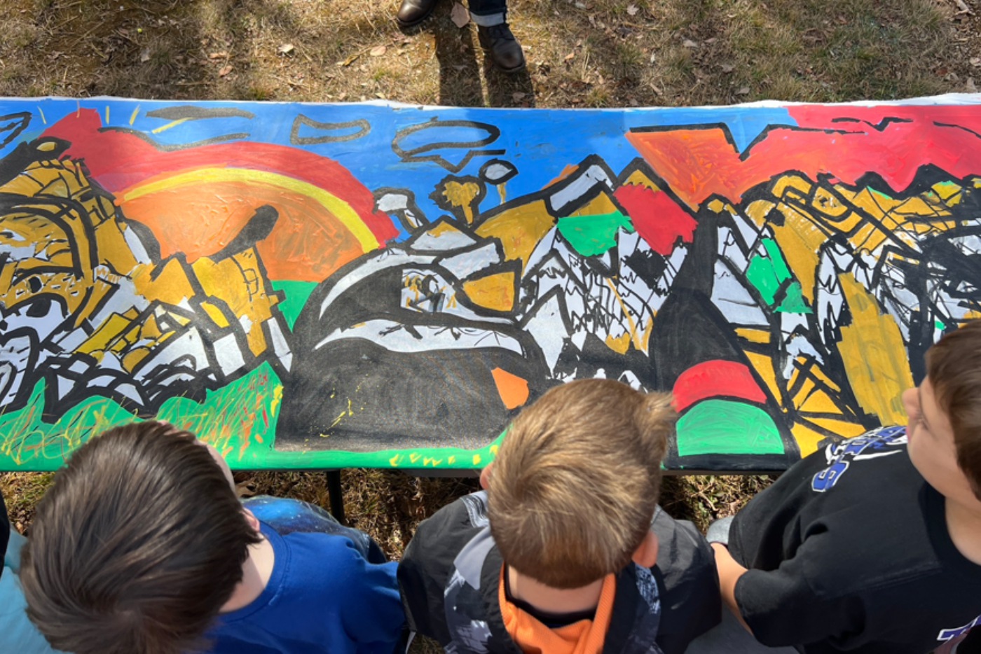 Students look down on their mural of the mountains.