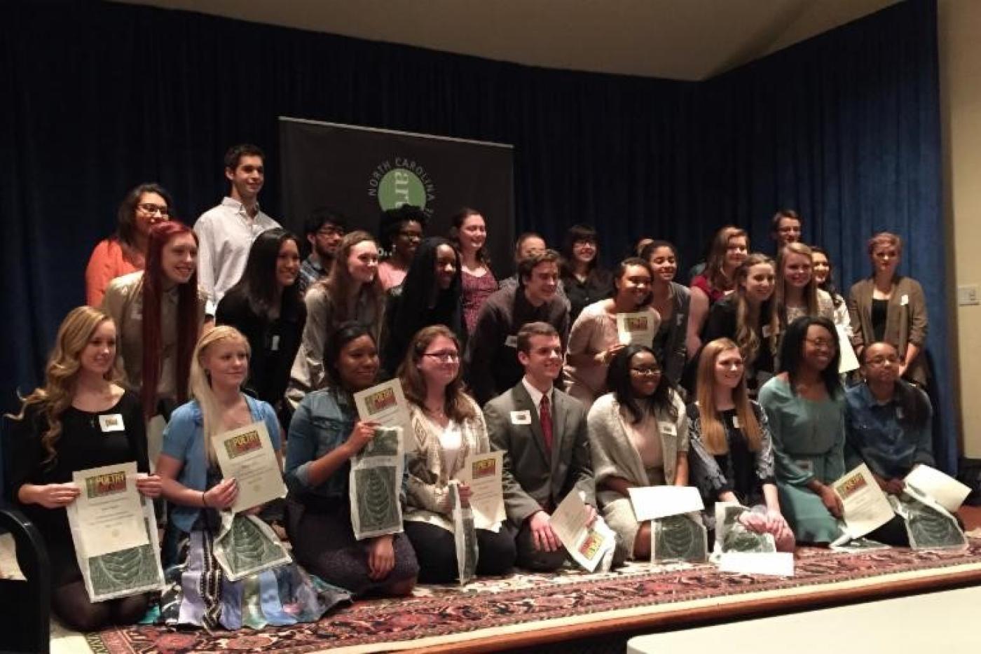 Rows of students holding certificates.