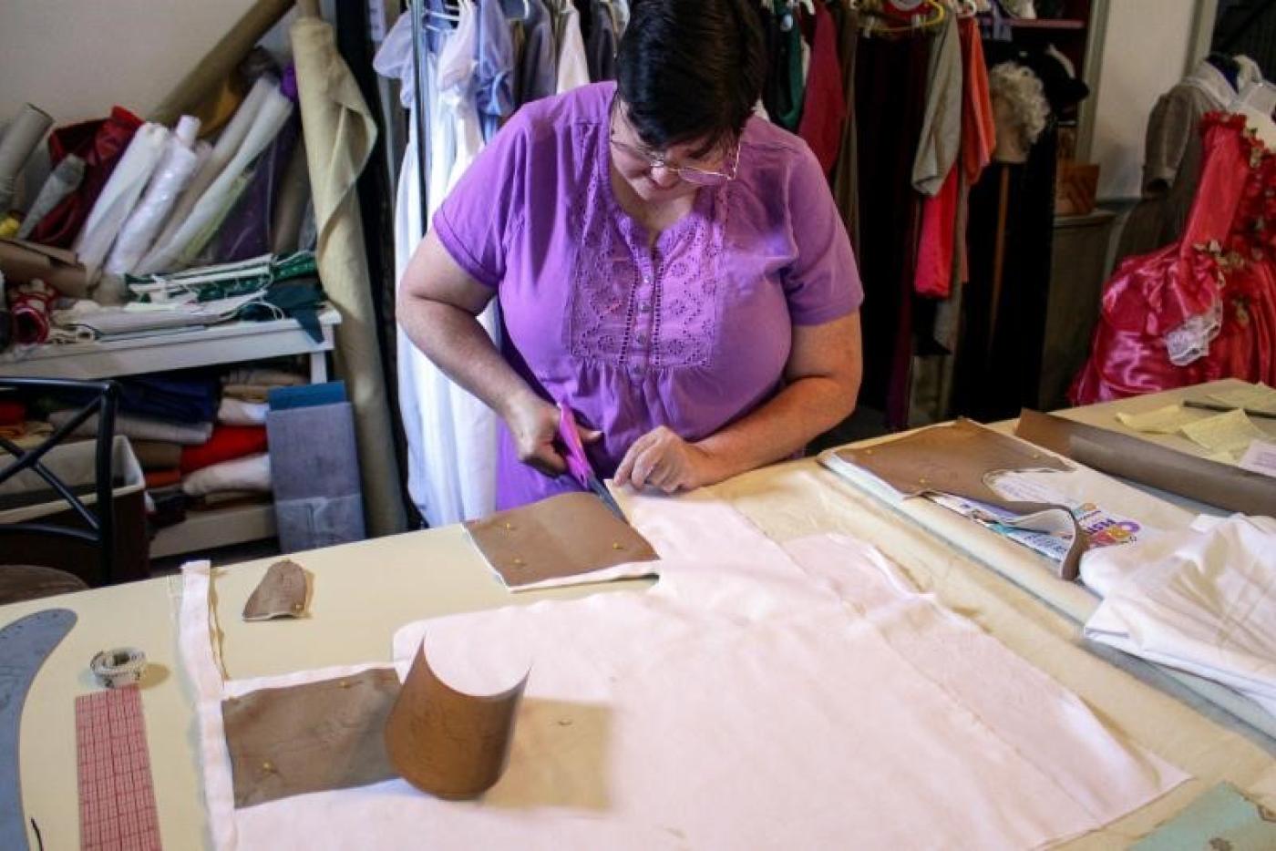 A woman cutting fabric.