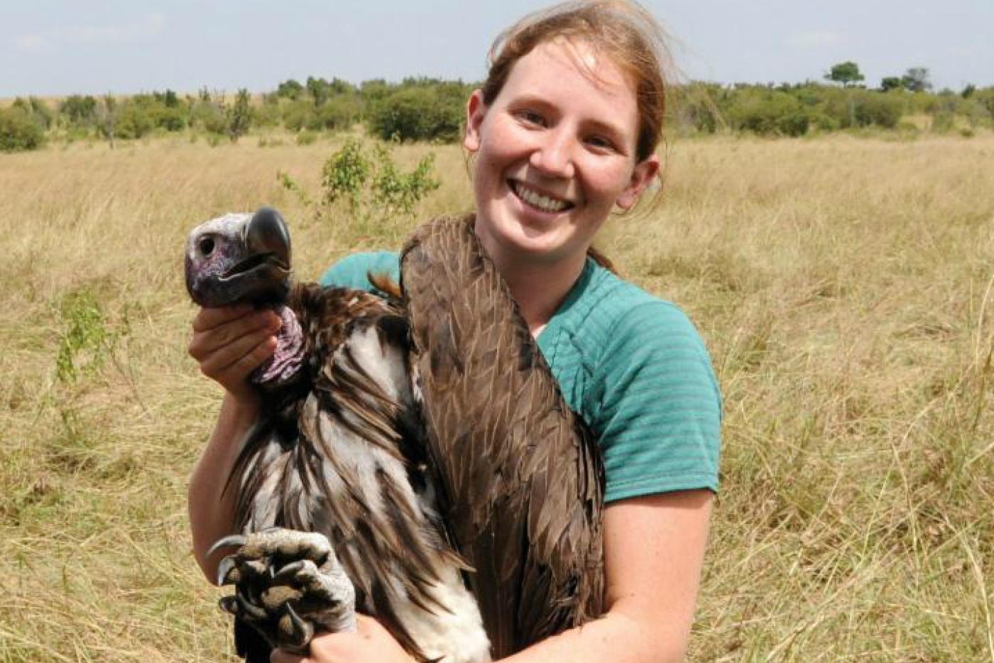 A zookeeper holding up a vulture.