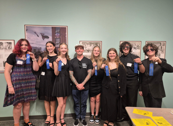 a group of students standing in a line and showing off blue ribbons
