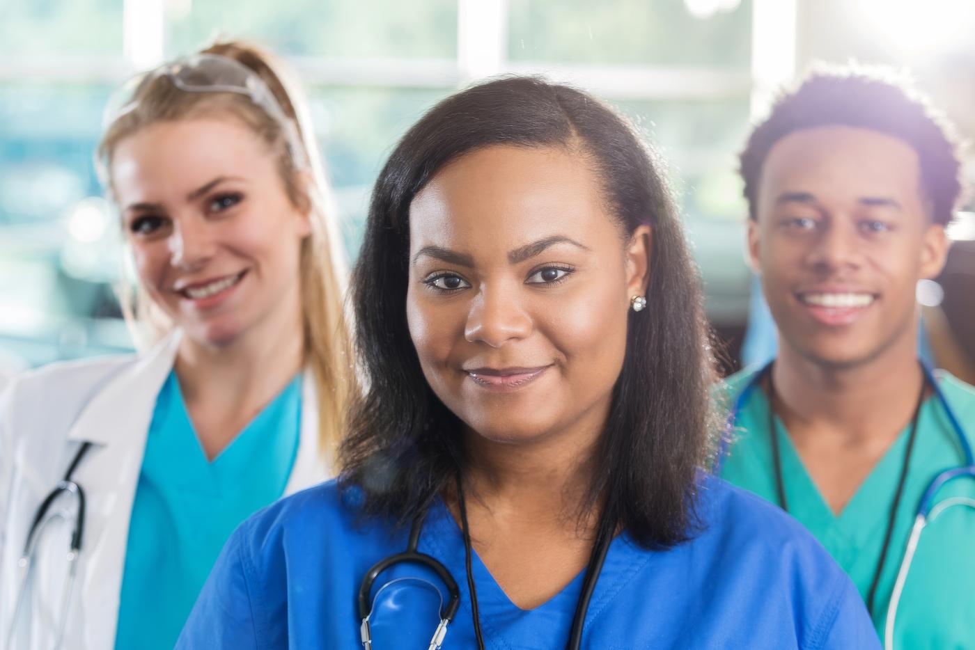 Three health professionals in scrubs