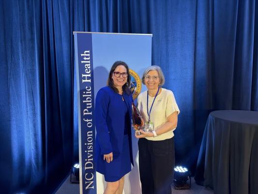 Kelly Kimple, DPH Director, presents the 2026 Levine Award to Jill Moore. 