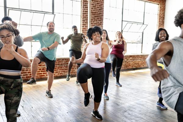 A diverse group of individuals doing aerobic exercise together.