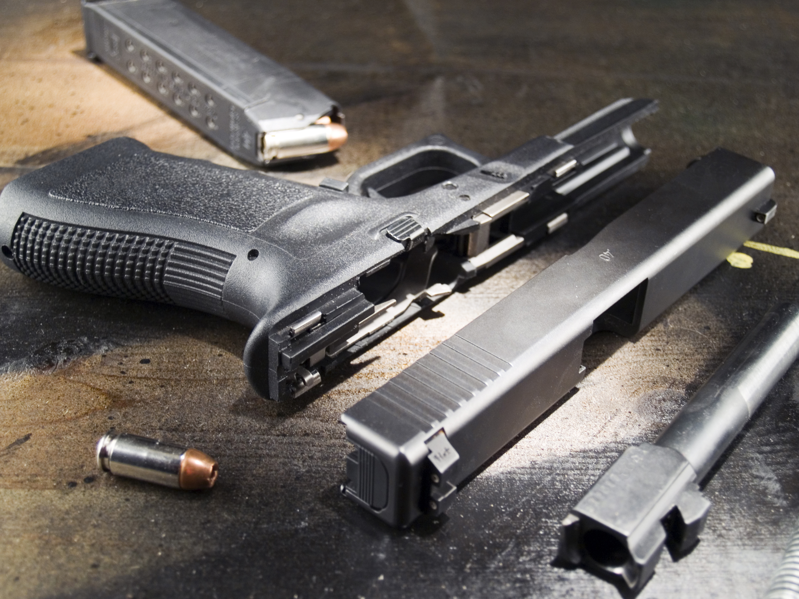 Parts of a handgun and bullets on a table.
