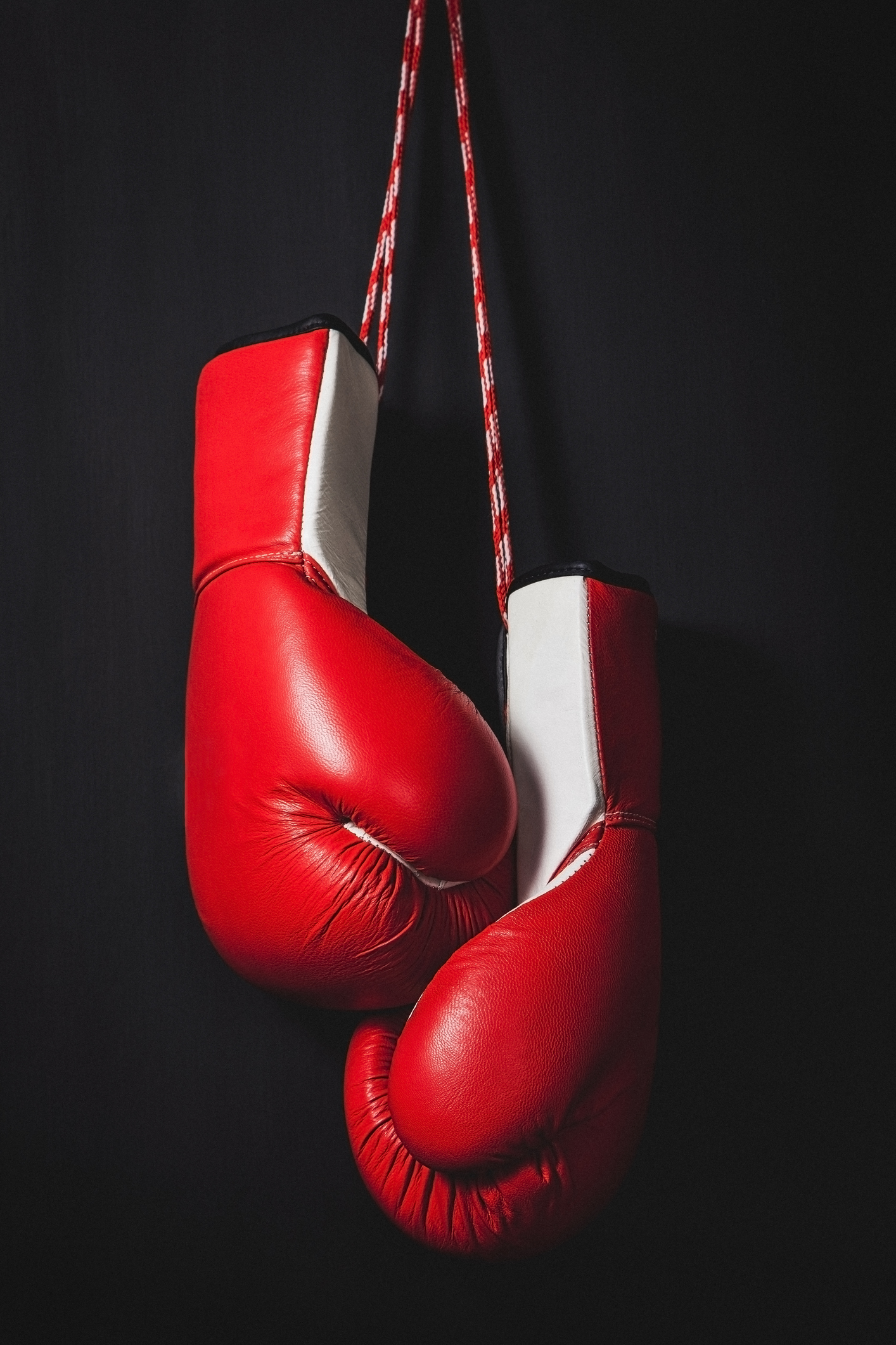 Red boxing gloves over black background.