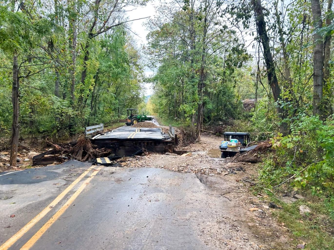 Washed out roadway with debris surrounding it