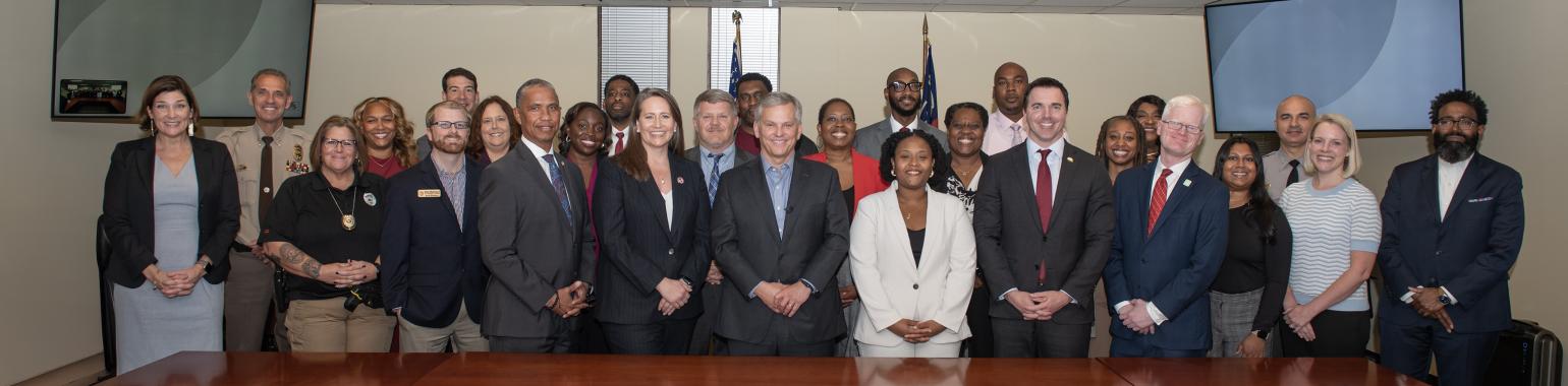 Multiple people pose in a line. The governor stands in the center.