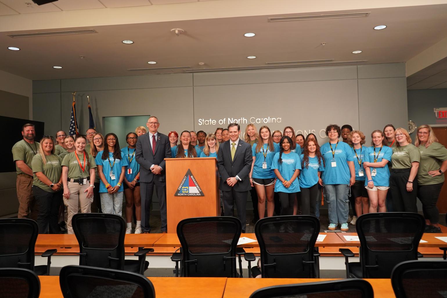 Group picture of camp participants in blue shirts and camp staff in green shirts.