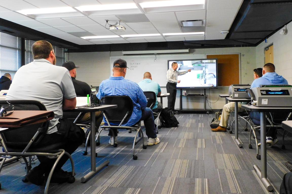 Classroom with instructor at front and students at desks.