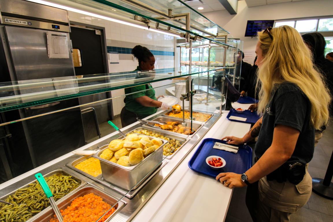 Food line with people waiting to be served.