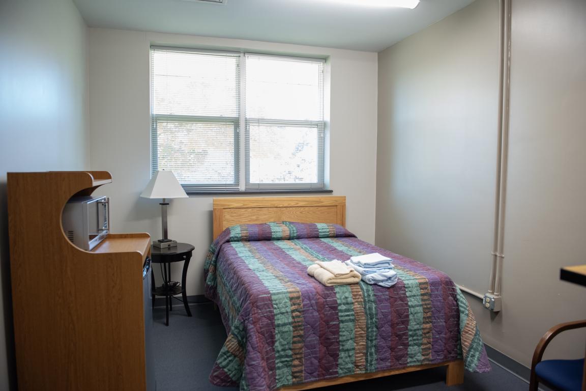 Room with bed, side table and desk.
