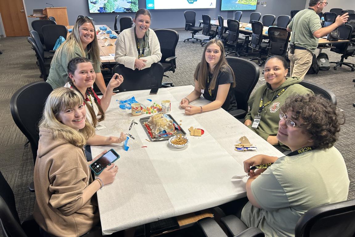 Seven women sitting at a table doing an activity together