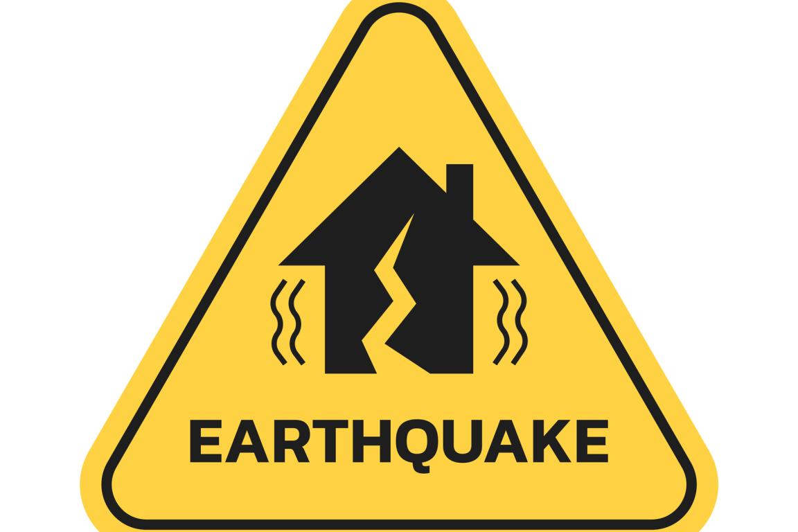 Yellow triangle "Earthquake" sign with a house pictured in the middle that has a crack going through it.