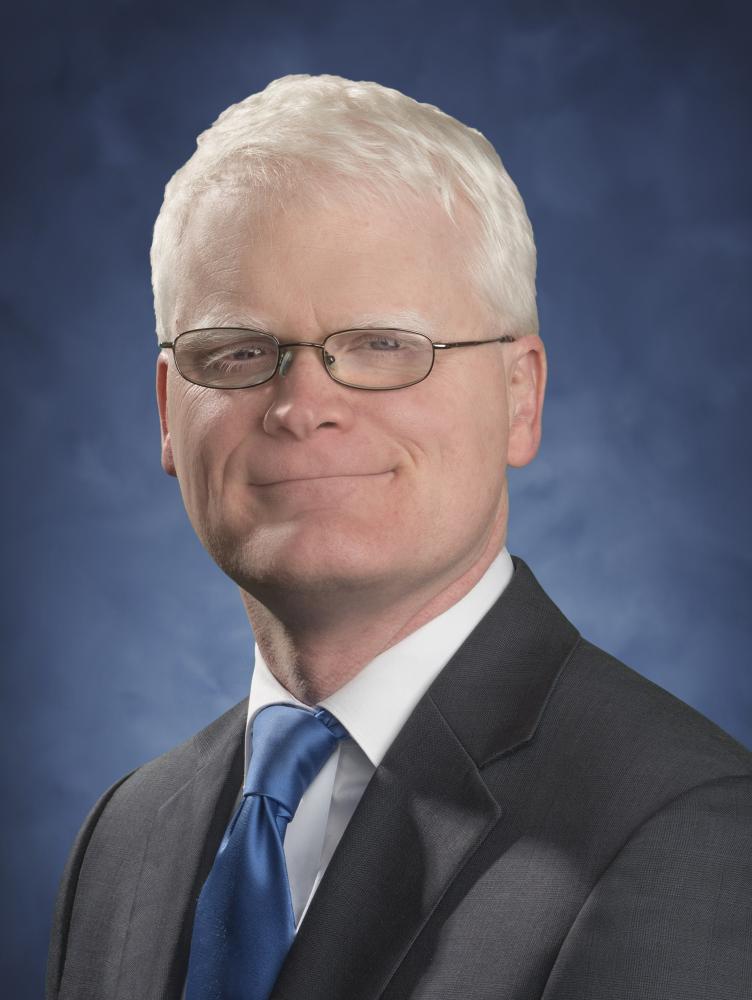 Billy Lassiter in front of blue background