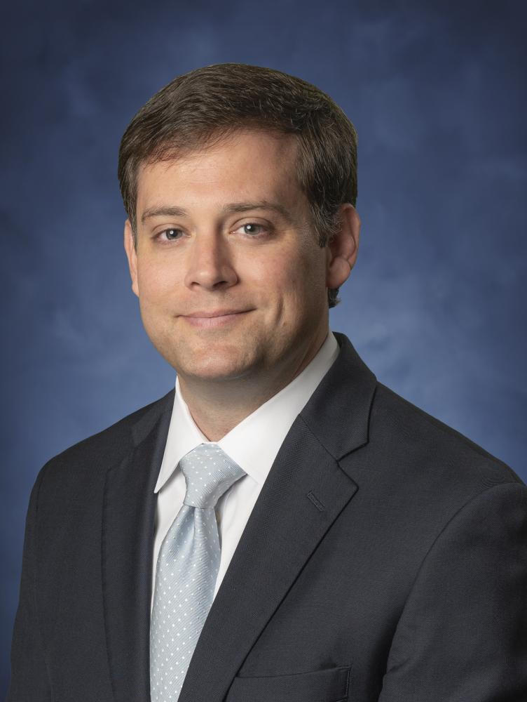 Will Ray in front of blue background