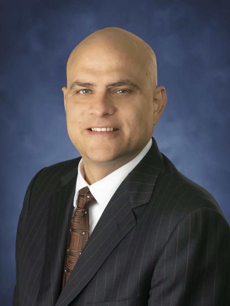 Matthew Rebuck in front of blue background