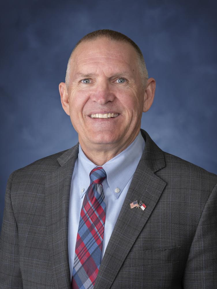 Portrait of Jeffrey Smythe. White male wearing grey suit.
