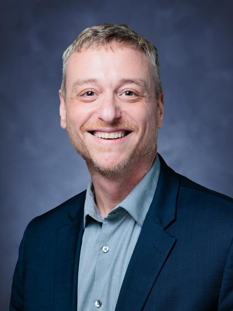 Mick DiGrazia, white male, wearing a blue button-up shirt and blue blazer.