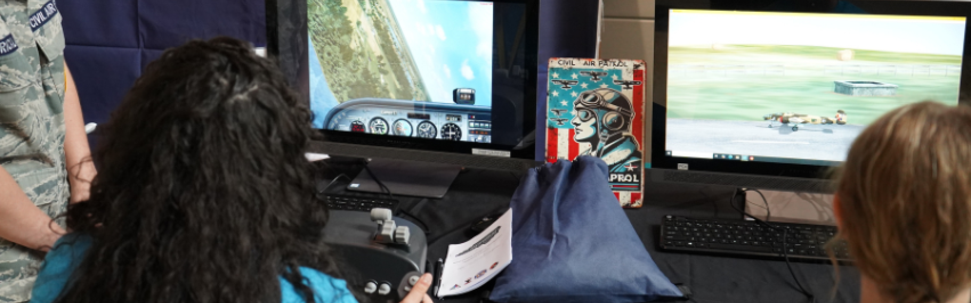 Two young women using a Civil Air Patrol flight simulator on computers