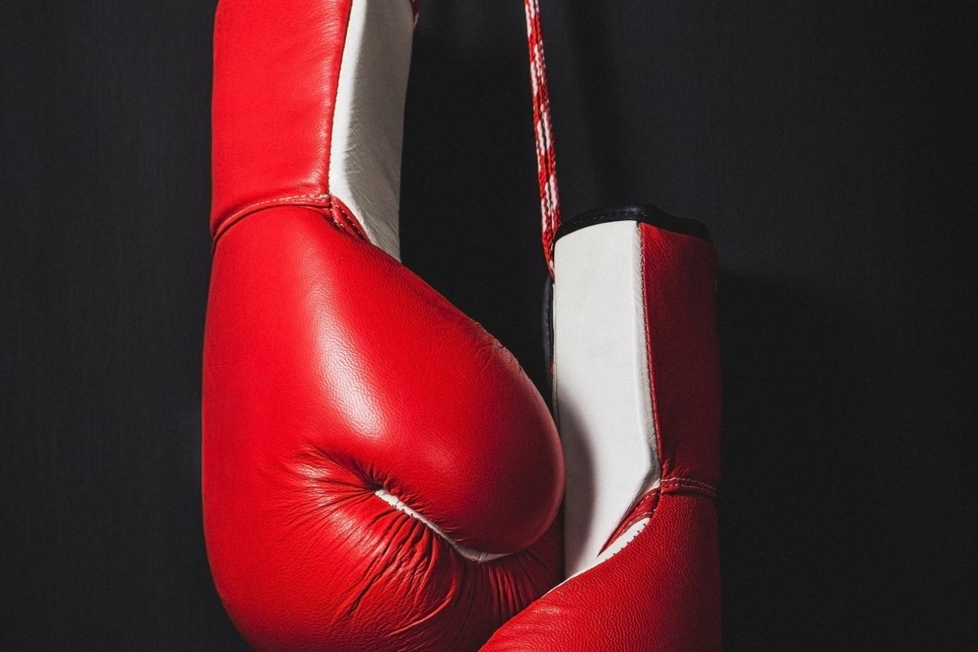 Red boxing gloves over black background.