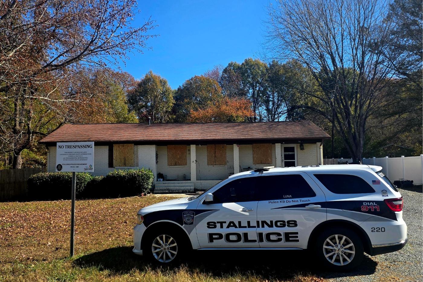 White brick house with a Stallings Police SUV in front of the house