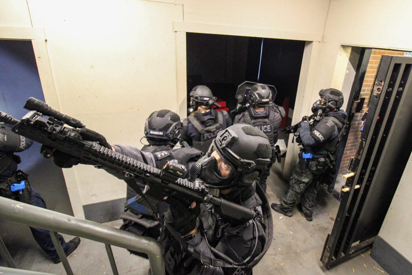 Multiple people dressed in protective helmets, padding and gloves in a room. 