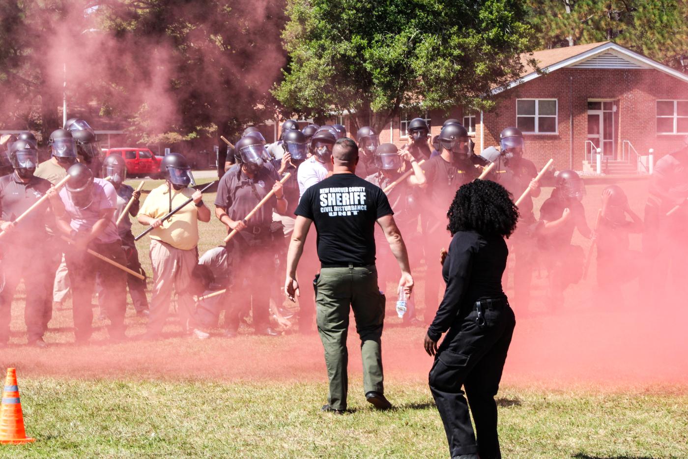Outdoor area where a group of people stand with red mist surrounding them.