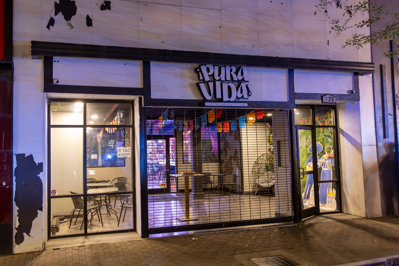White building with black siding with Pura Vida sign