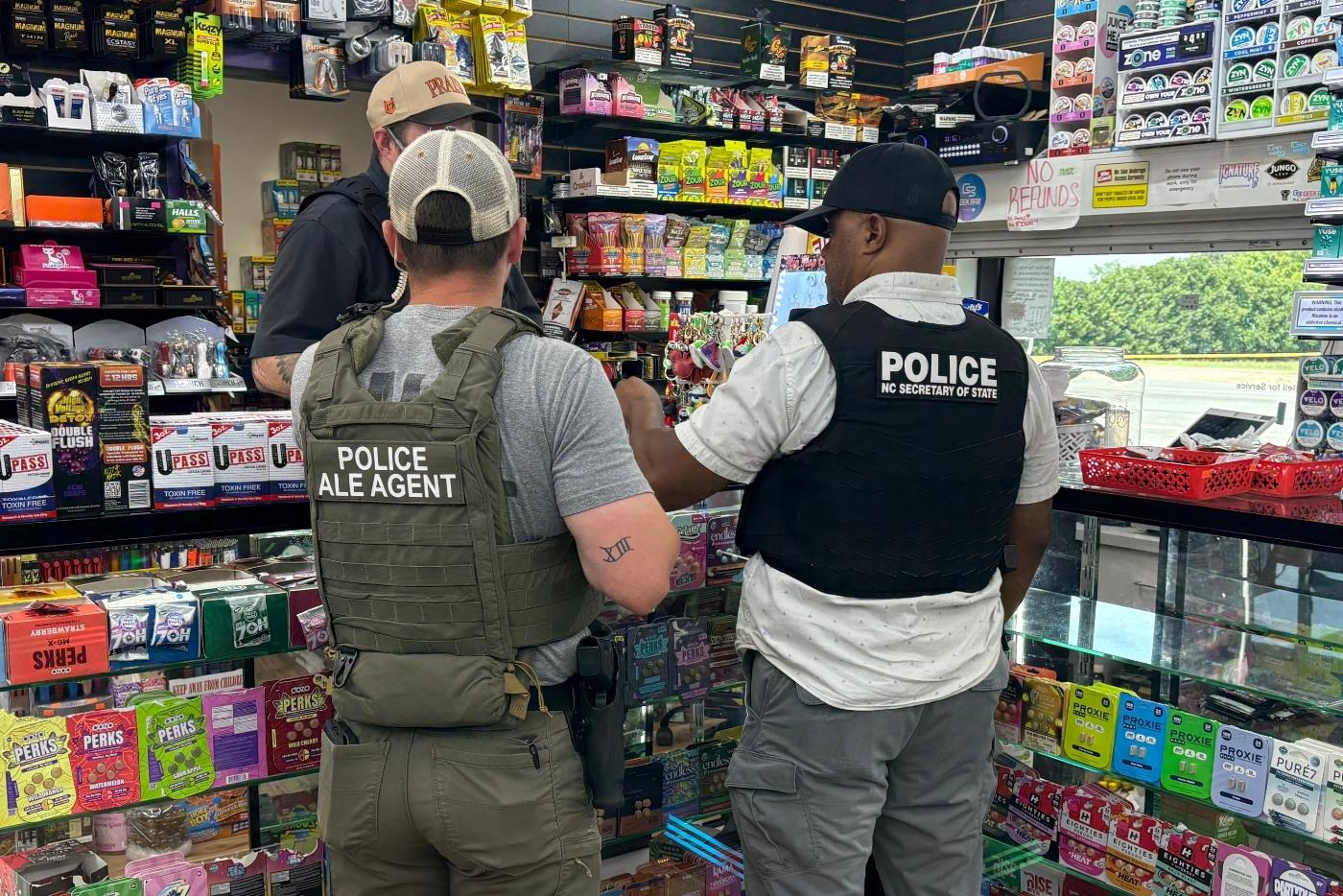 two law enforcement officials standing at a counter in a tobacco store