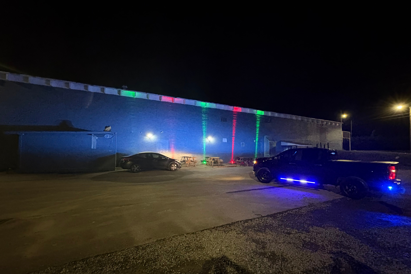 Brick building with police truck in front with blue lights on