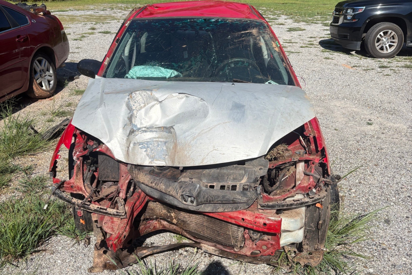 Wrecked Red Honda car with silver front hood damage