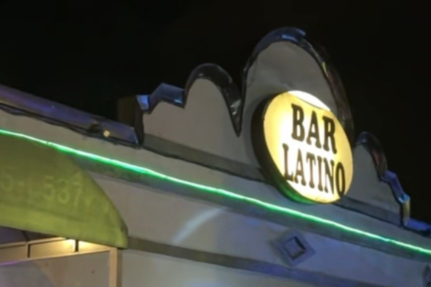 Grey and black building with yellow illuminated sign