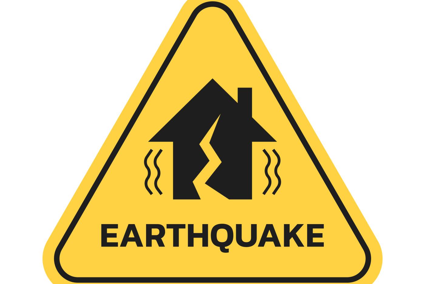 Yellow triangle "Earthquake" sign with a house pictured in the middle that has a crack going through it.
