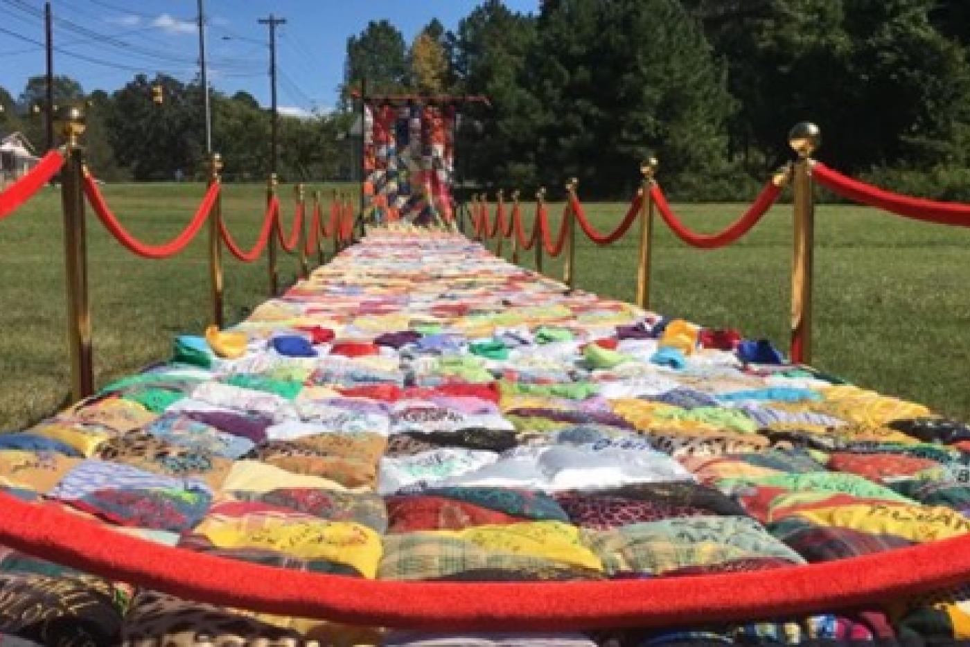 Photo showing multi-colored quilt on lawn