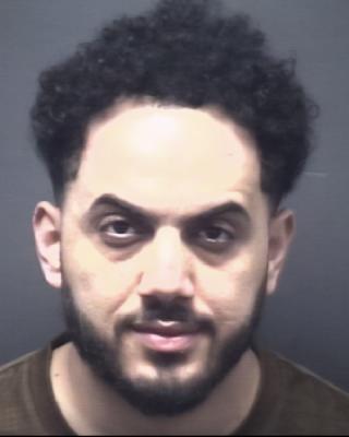 Jail booking of Salah wearing a brown shirt with black hair