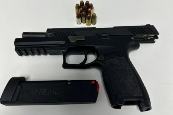 Black pistol with magazine out and bullets laying on table