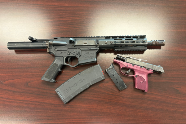 two firearms on dark wood table